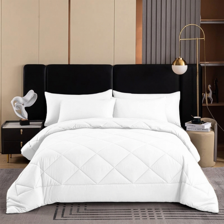 White quilted bedspread set styled neatly on a bed in a minimalist bedroom setting