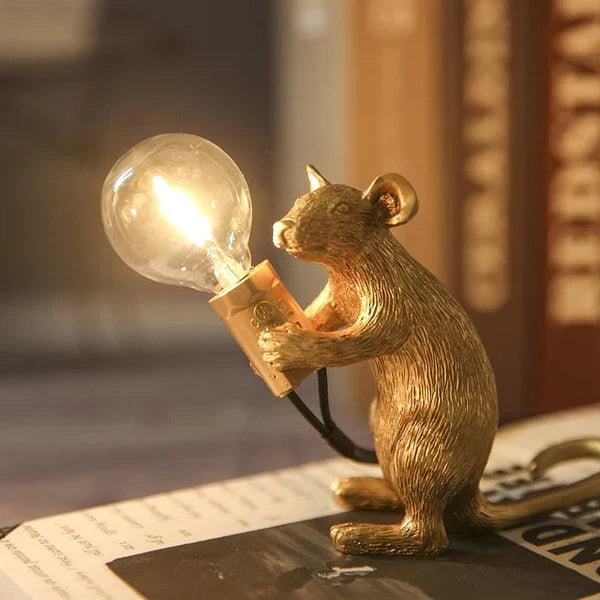 Decorative lighting piece featuring cute mouse holding bulb on table