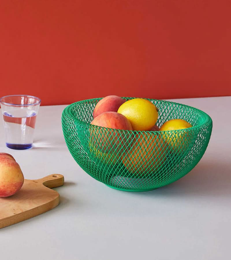 Green wire mesh fruit bowl displayed on a kitchen counter