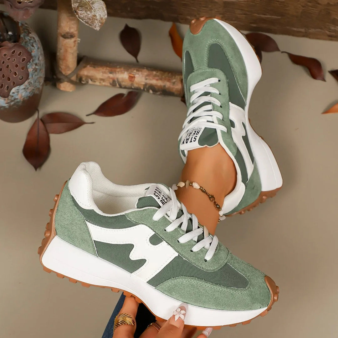 Women's green striped platform sneakers shown in stylish studio lighting