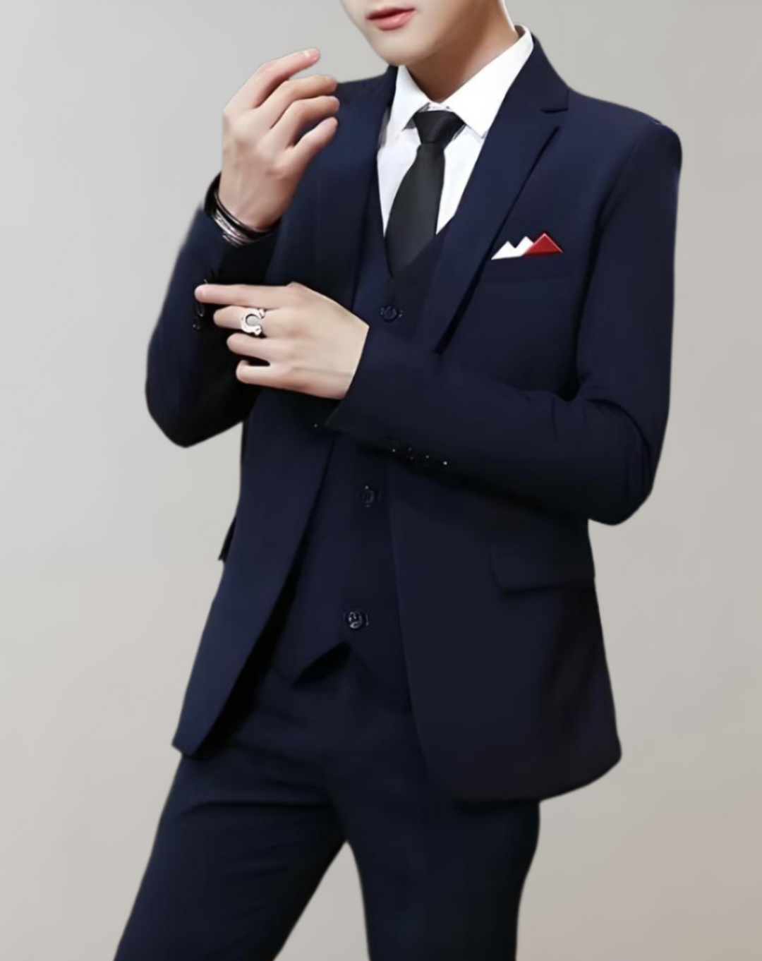 Man wearing a navy blue 3-piece suit adjusting his cuff