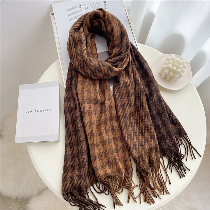 Women's checked winter scarf draped elegantly, showing classic plaid pattern and soft fabric.