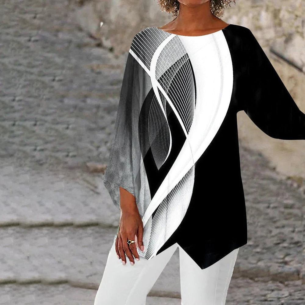 Model wearing a black and white geometric long sleeve tunic paired with white trousers