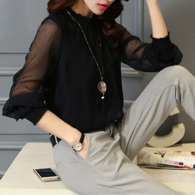 Woman wearing a stylish black long sleeve chiffon blouse with ruffles