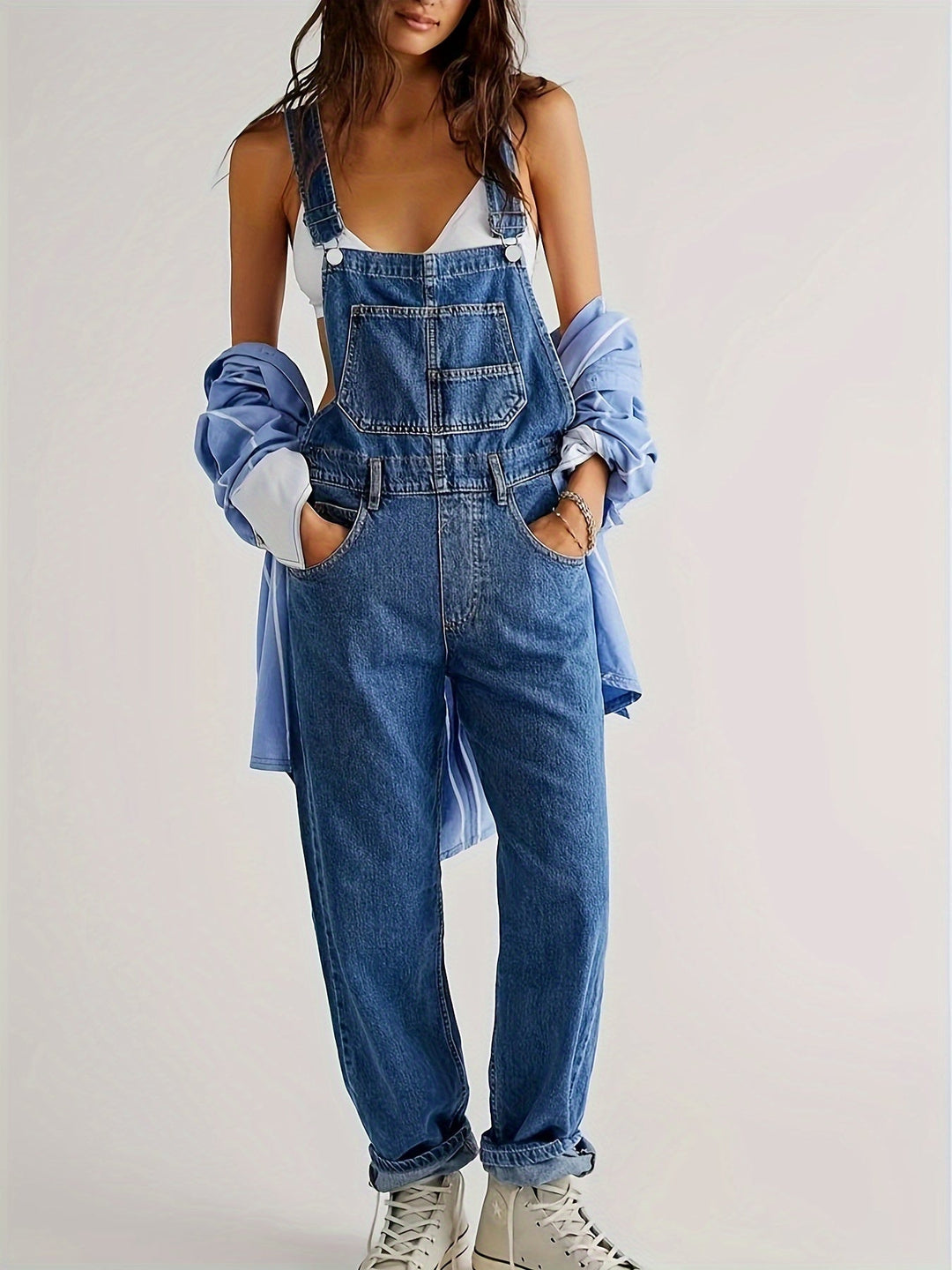 Full view of women's casual denim jumpsuit in light blue with front pockets
