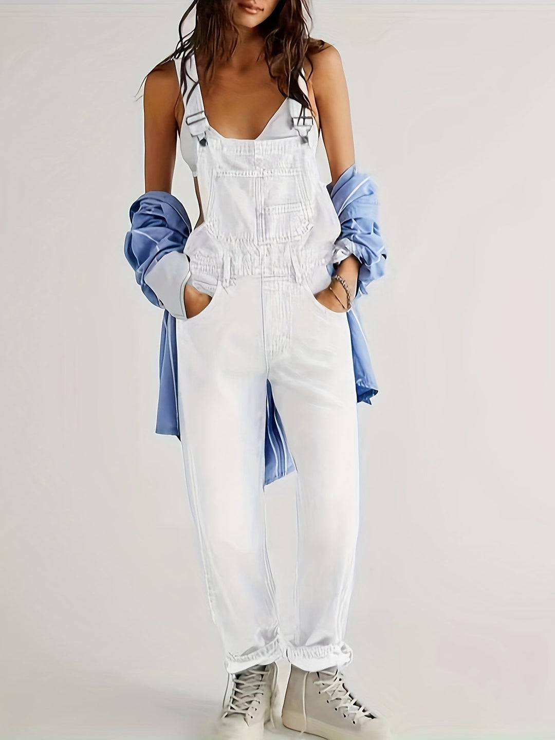 Full length view of a white denim jumpsuit with layered styling