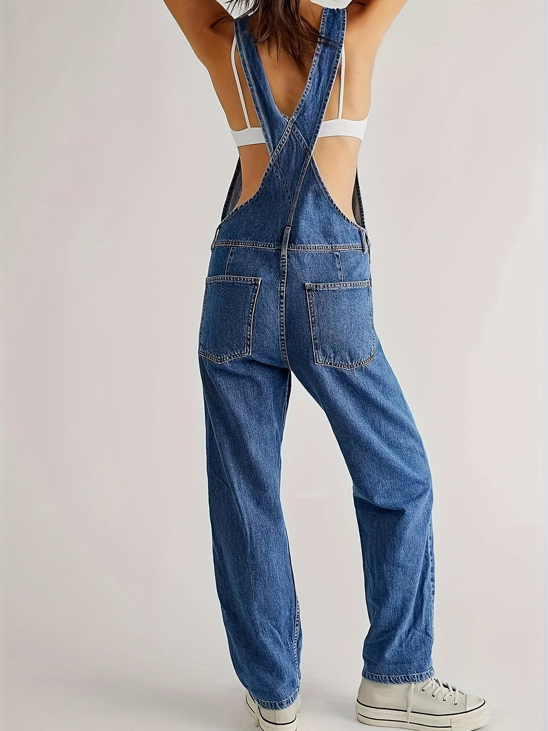 Back view of relaxed fit pocket denim jumpsuit with adjustable straps