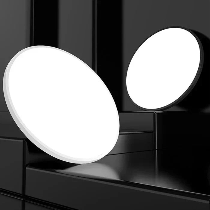 OrbGlow LED ceiling light turned on in a minimalist hallway, demonstrating bright illumination.