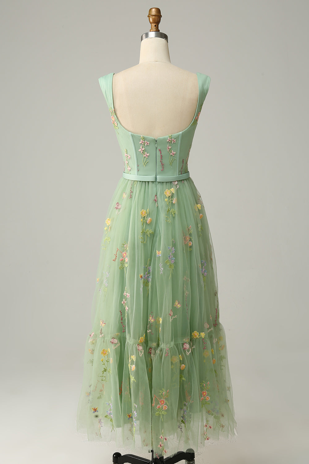 Back view of green embroidered a-line ball gown showing straps and zipper