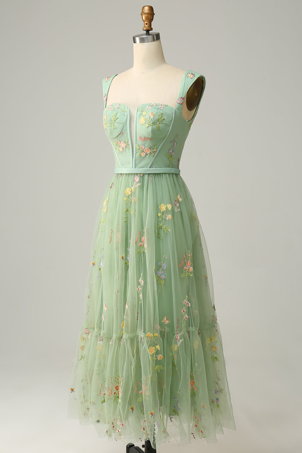 Angled side view of green embroidered a-line ball gown displaying bodice details