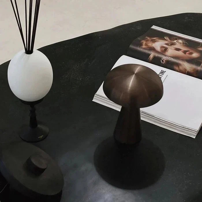Rechargeable desk lamp casting warm light on a modern bedside nightstand
