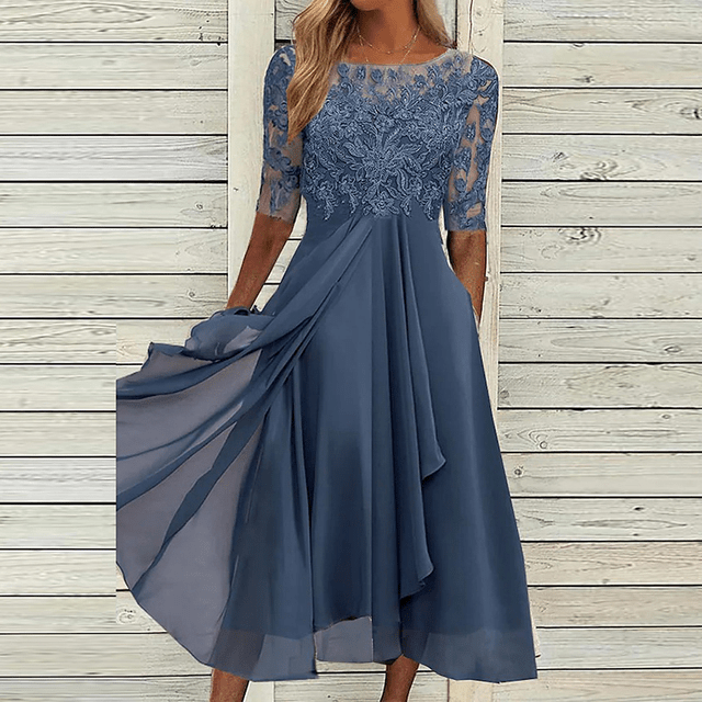 Woman wearing a navy blue lace accent summer dress against a wooden backdrop
