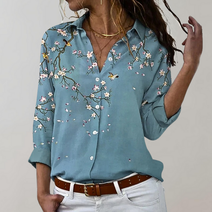 Woman wearing blue blouse with cherry blossom branch pattern