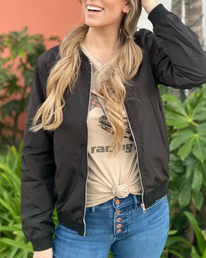 Woman smiling in a casual black bomber jacket paired with jeans