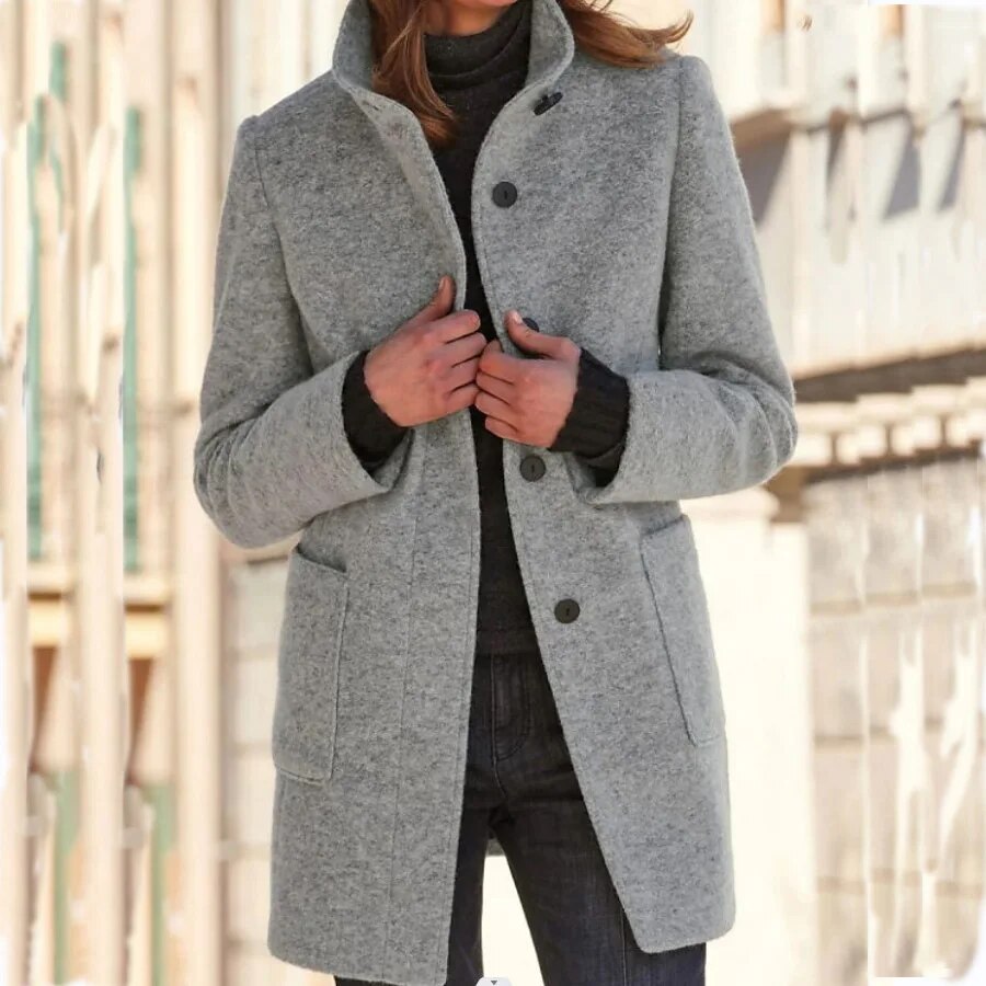 Woman wearing the Emma winter overcoat in grey with high collar