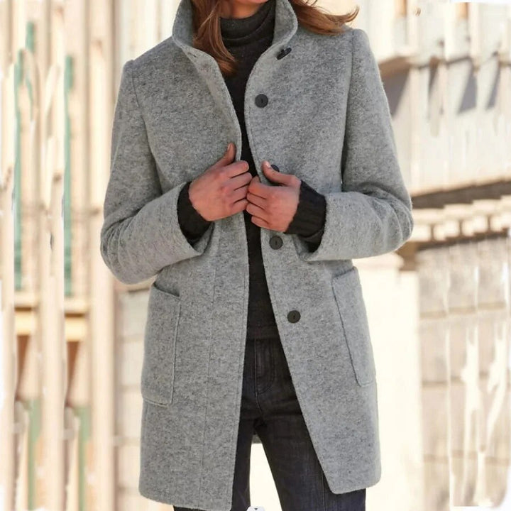 Woman wearing the Emma winter overcoat in grey with high collar