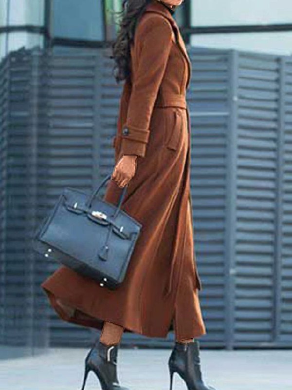 Side profile of a woman wearing a long brown winter coat and black boots