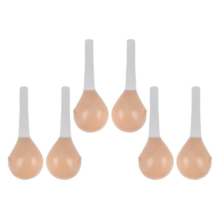 Multiple pairs of nude adhesive lift bras laid out together