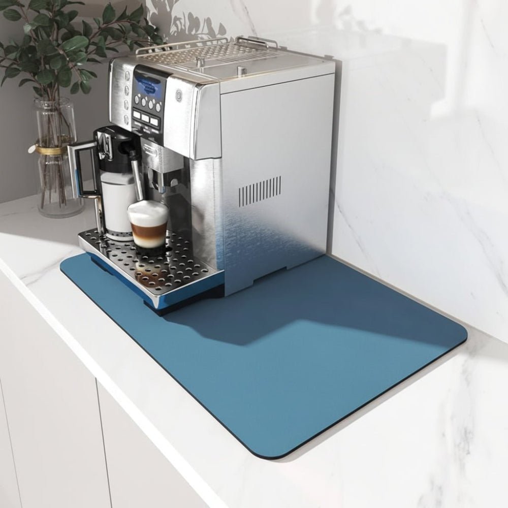 Dark blue coffee bar mat under an espresso machine on a marble countertop