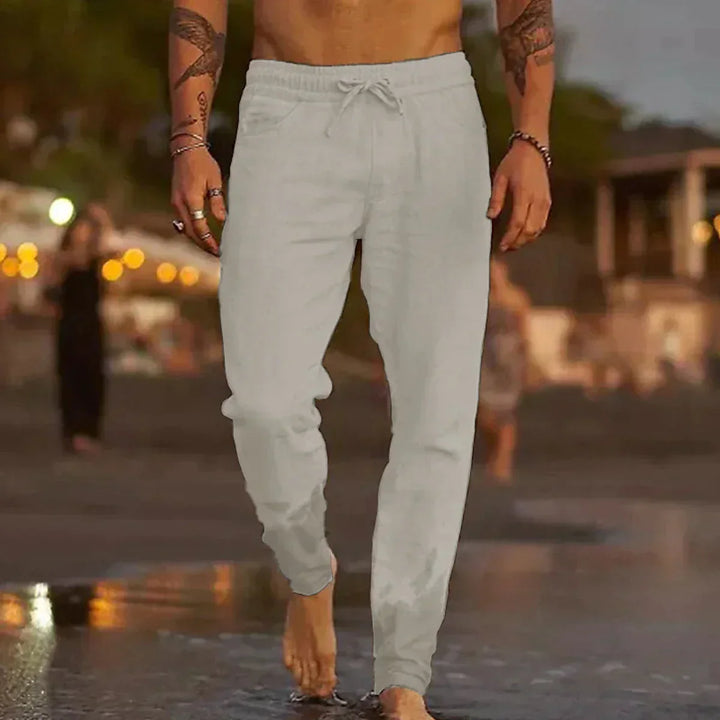 Man wearing light grey trousers outdoors in the evening