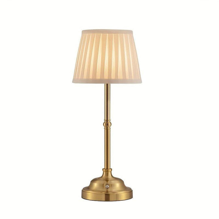 Beige table lamp with pleated tapered shade and gold base on white background