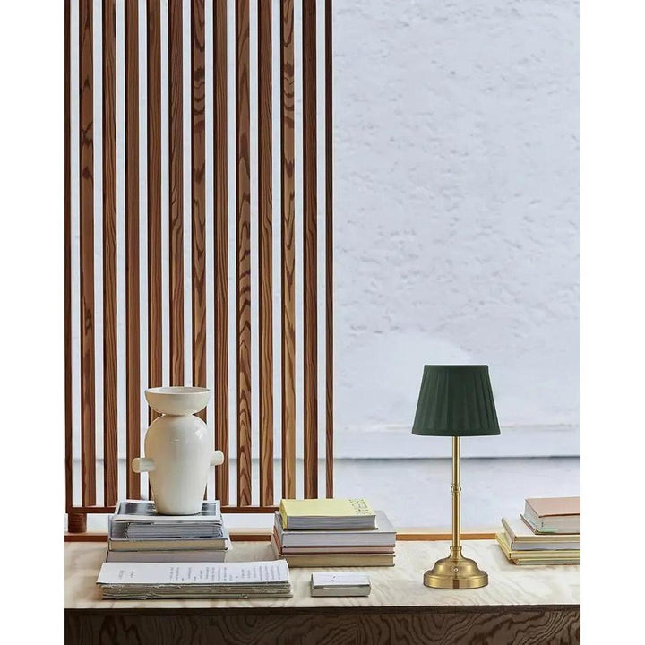Green table lamp with beige tapered pleated shade for modern home lighting and desk decor