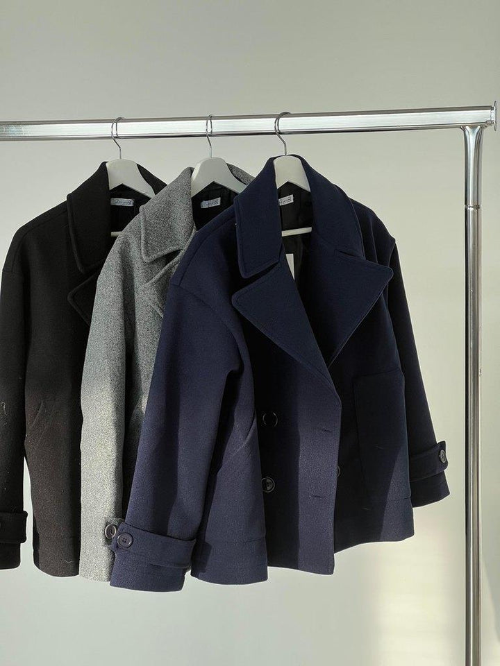 Detailed view of the tailored sleeve cuff on the grey outerwear