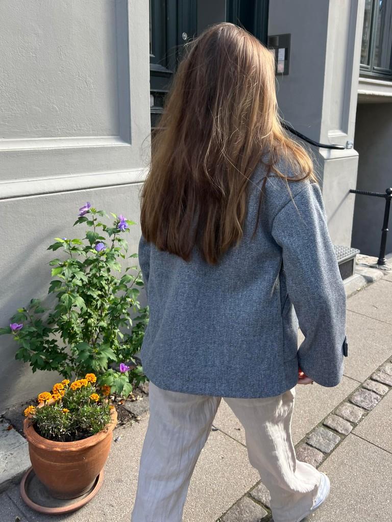 Full-length view of the grey winter coat worn over winter fashion layers