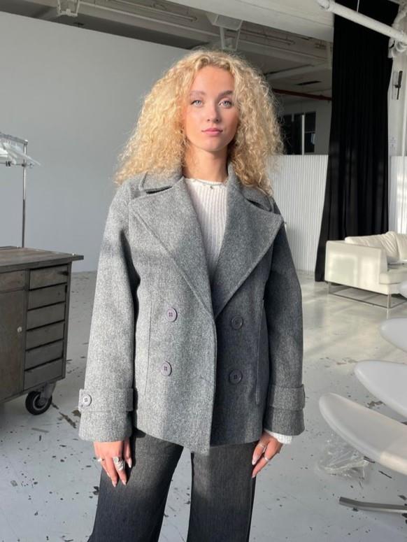 Close-up of the grey tailored winter coat with oversized collar in a studio setting