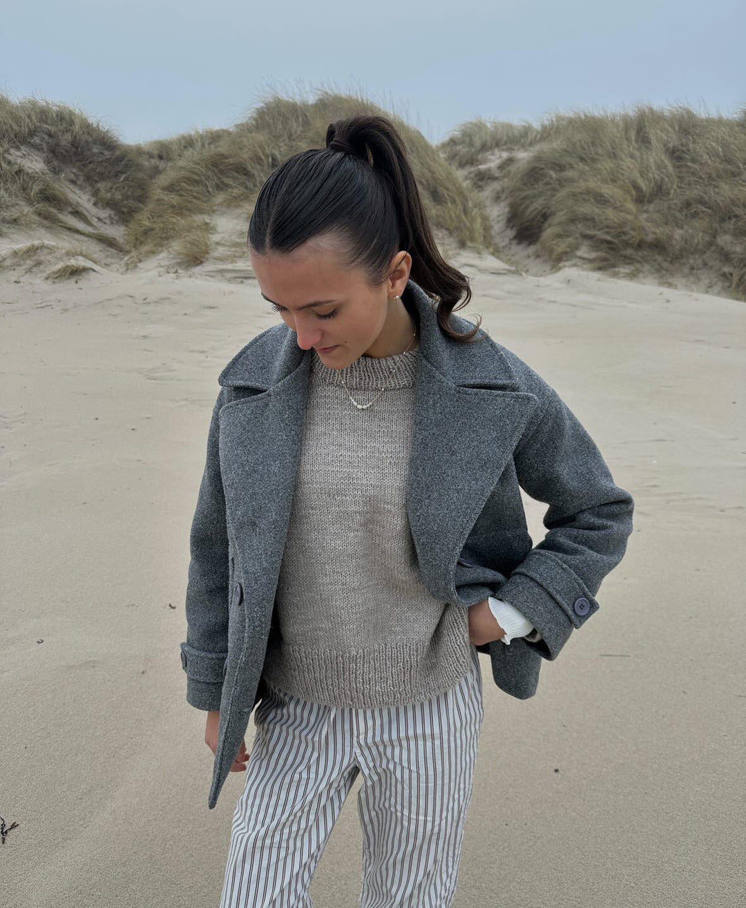 Model wearing the grey winter coat styled for a casual outdoor look