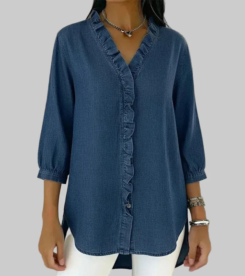 Woman wearing a dark blue v-neck ruffle blouse with three-quarter sleeves