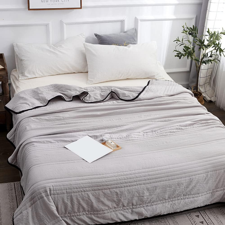 Gray ice cooling blanket spread neatly over a queen size bed