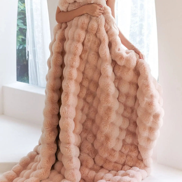 Warm winter blanket spread across a queen-size bed with cozy bedding pillows.