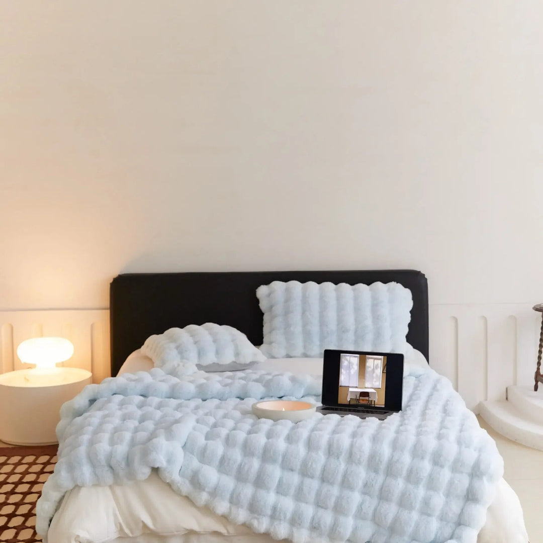 Person wrapped comfortably in a lightweight, cozy throw blanket while relaxing indoors.