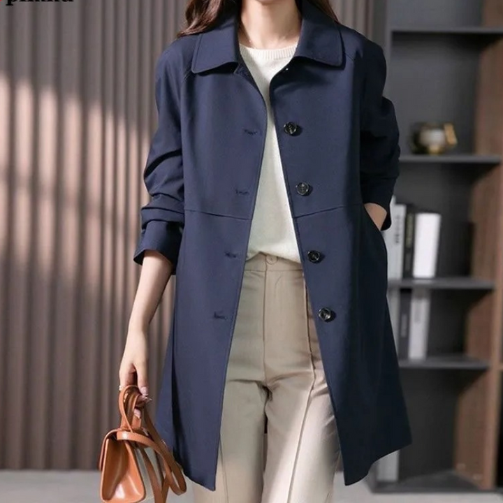 Front view of the Theresa dark blue trench coat with collared neckline and buttons