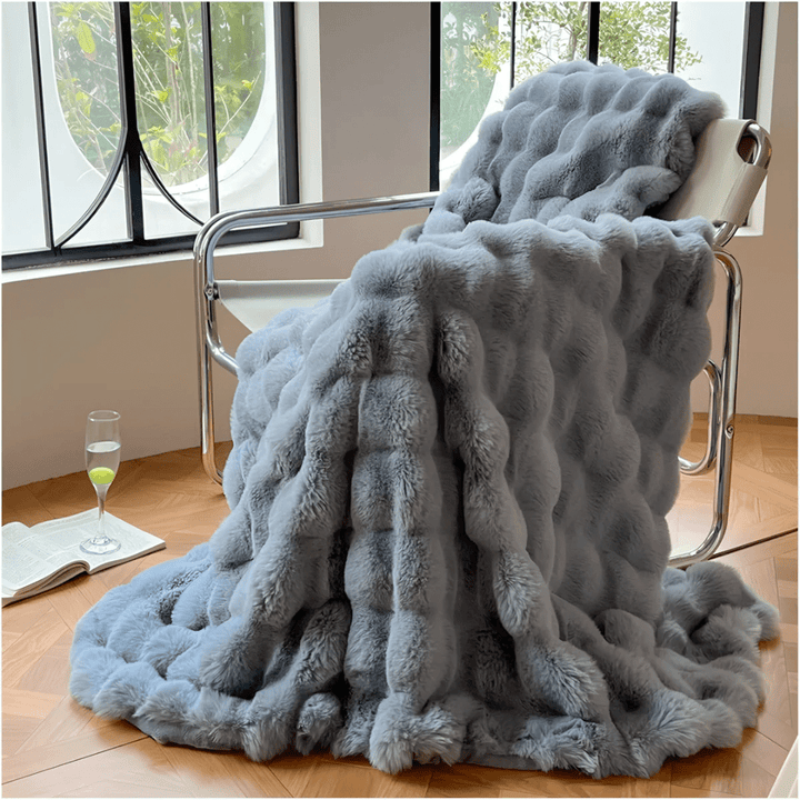 Folded travel blanket featuring modern design and easy care soft fleece material.