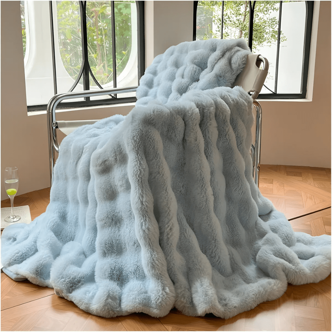 Cozy unisex ultra-soft thermal fleece blanket draped neatly over a modern sofa.