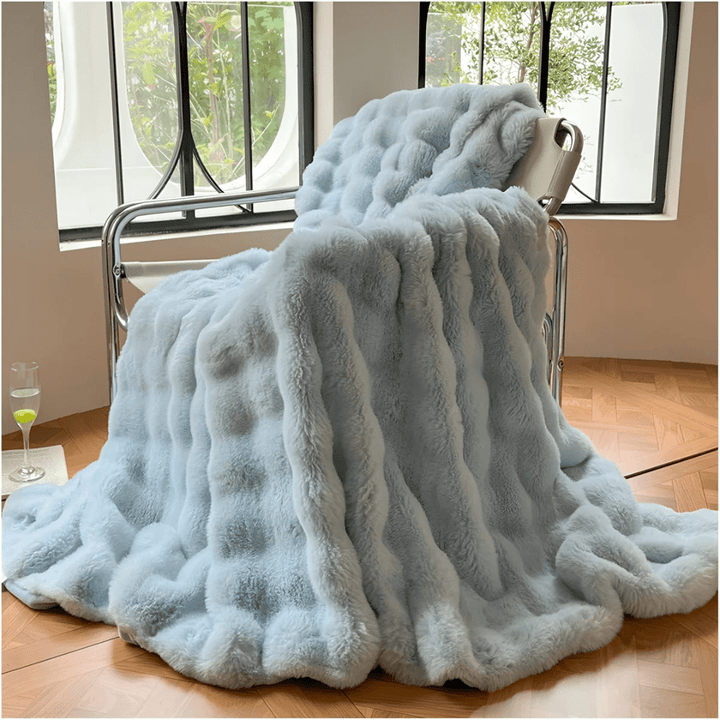 Cozy unisex ultra-soft thermal fleece blanket draped neatly over a modern sofa.