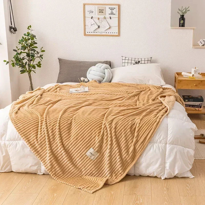 Plush bedding blanket in neutral tone spread flat to display full size and softness