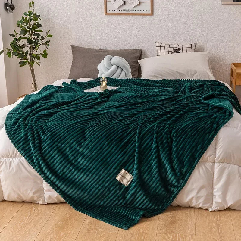 Full view of the dark green flannel blanket styled on a white bedspread