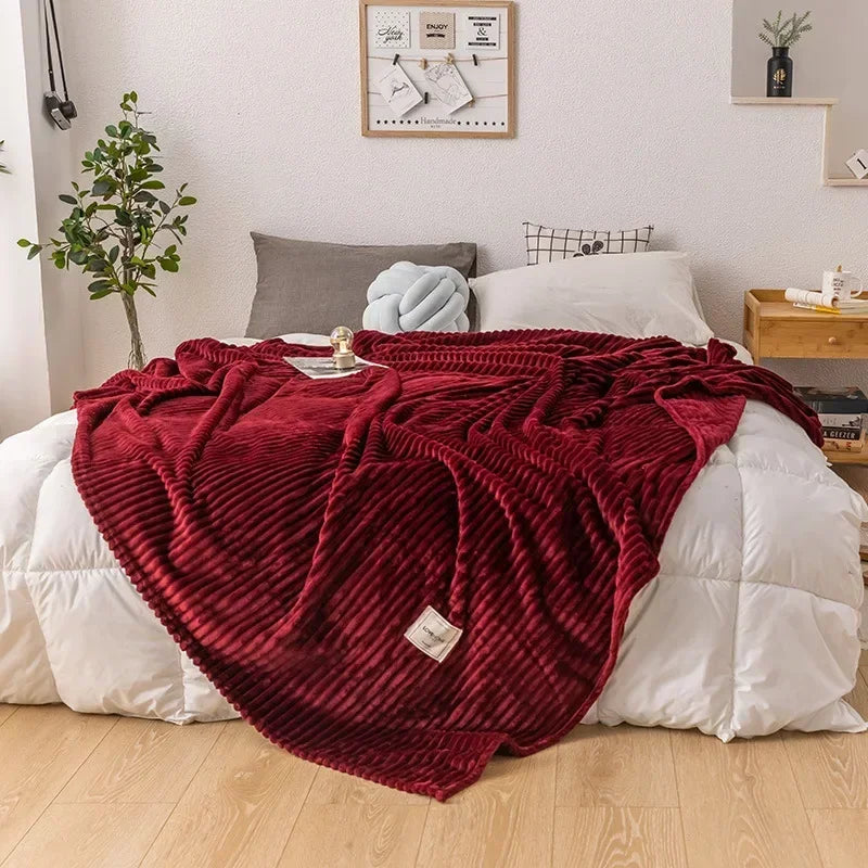 Dark red thick flannel autumn blanket beautifully displayed on a cozy bedroom bed