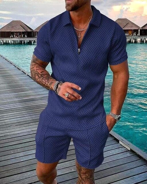 Man wearing a navy blue polo and shorts coordinated summer set on a wooden pier