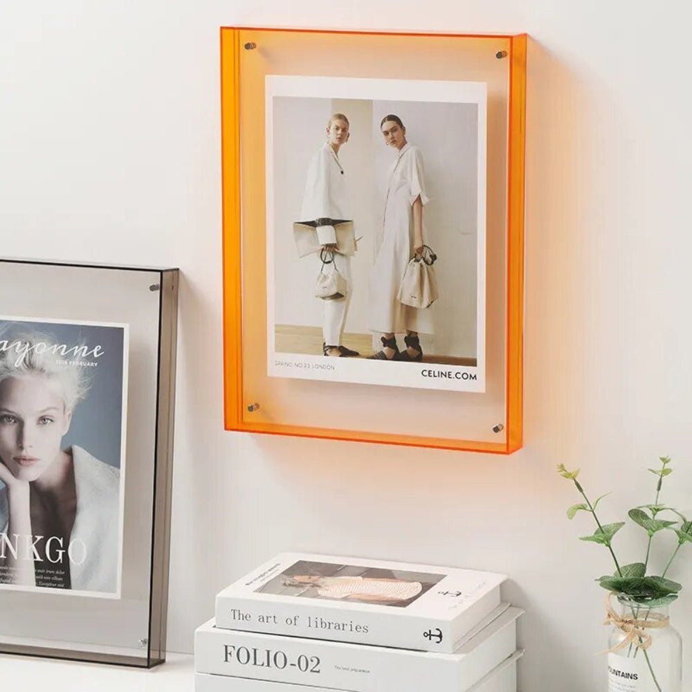 Orange transparent acrylic floating photo frame displaying fashion print on a wall