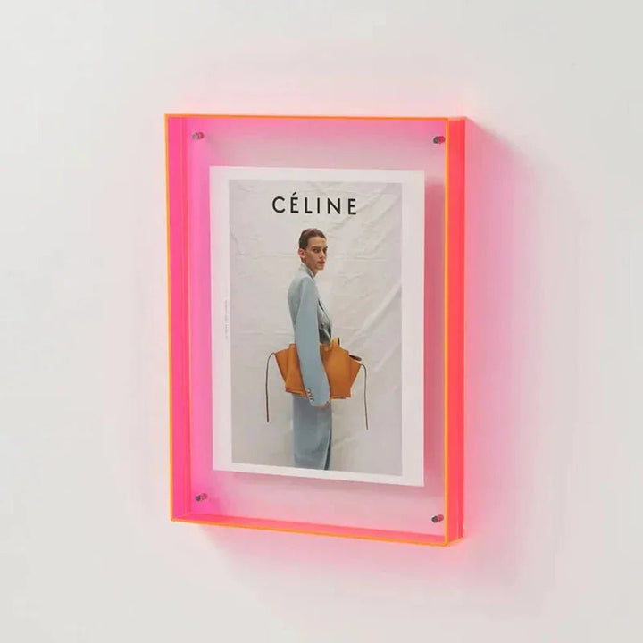 Set of clear acrylic picture frames arranged vertically on a white wall