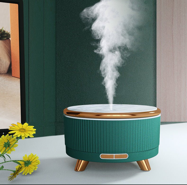 Modern green and marble aroma diffuser emitting a fine mist next to yellow flowers
