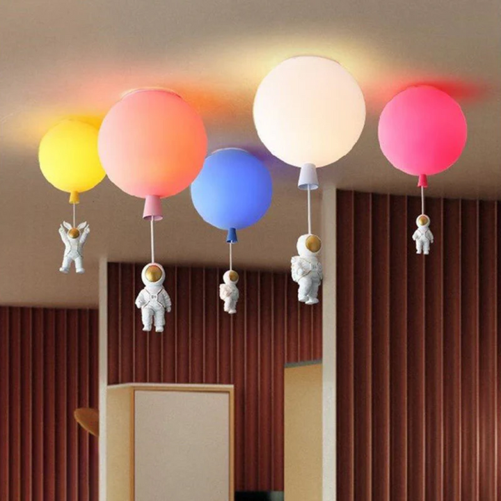 Colorful globe hanging pendant lights featuring miniature spacemen in various bright colors
