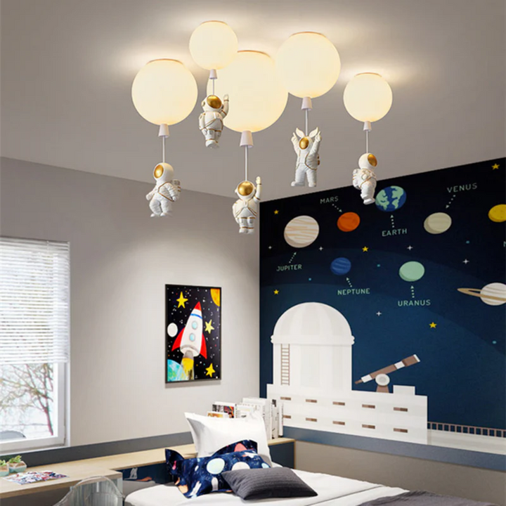 Astronaut themed bedroom interior featuring a glowing moon ceiling fixture above a planetary wall mural