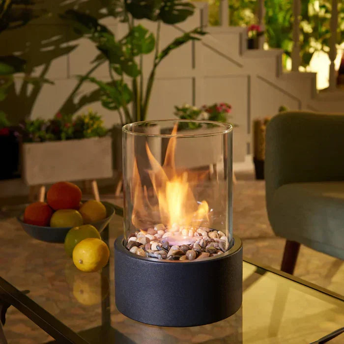 Modern portable tabletop fire lantern glowing on a glass coffee table