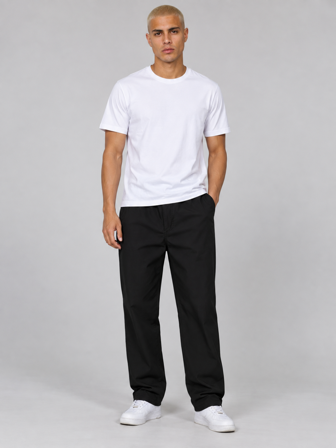 Model standing facing forward wearing black lightweight hiking trousers and a white t-shirt