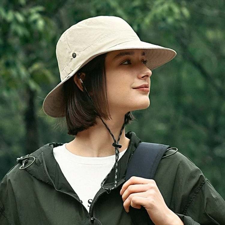 Woman wearing a beige wide brim sun hat outdoors